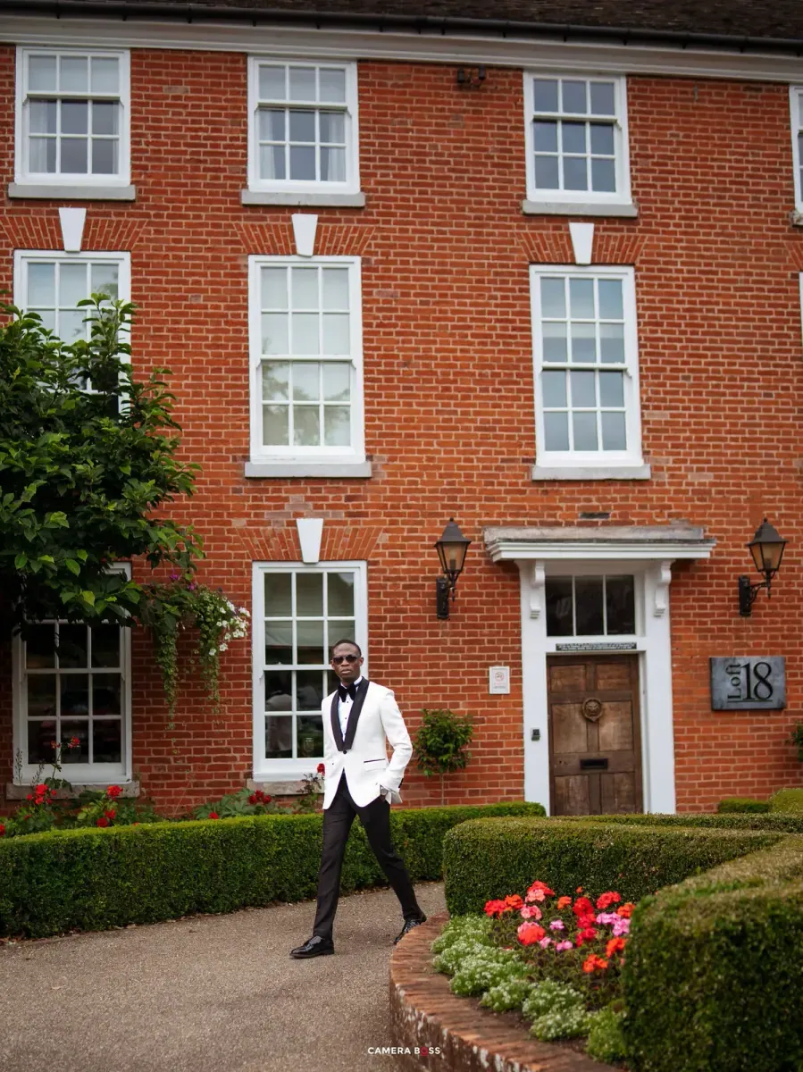 Bride beside a red brick facade. CameraBoss portfolio: Temi and Fiyin.