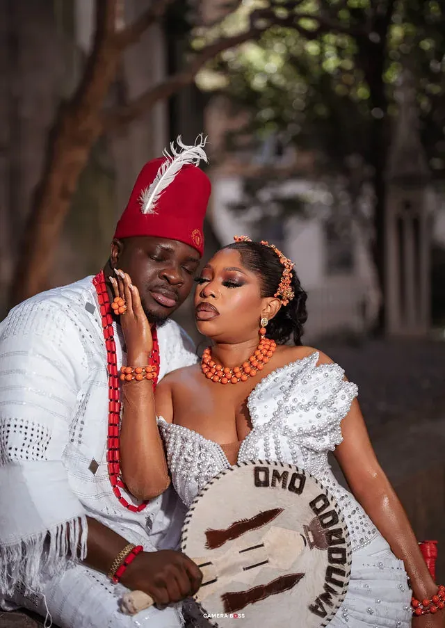 A couple seated together in white formal attire. CameraBoss portfolio: Korede Prewedding.