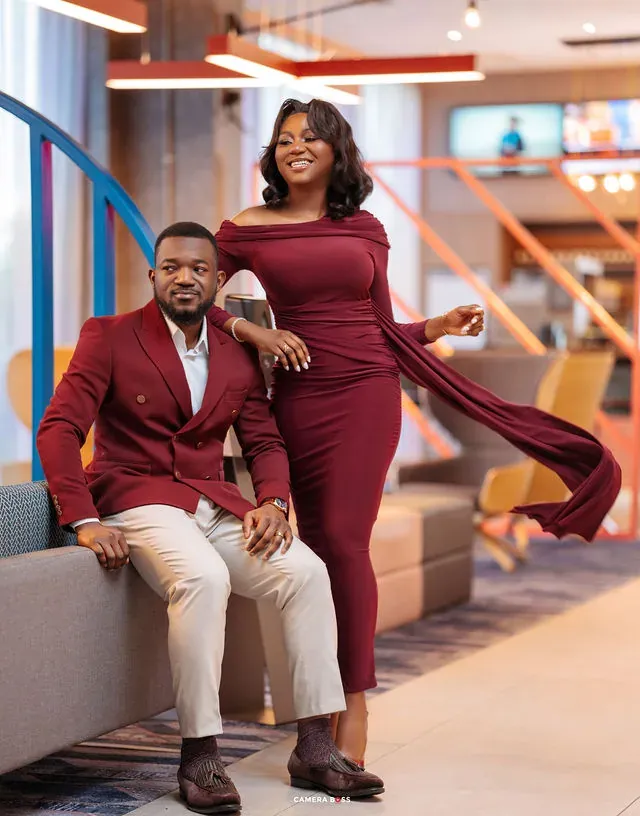 A couple in coordinated red attire beside a staircase. CameraBoss portfolio: Tolu Prewedding Birmingham.