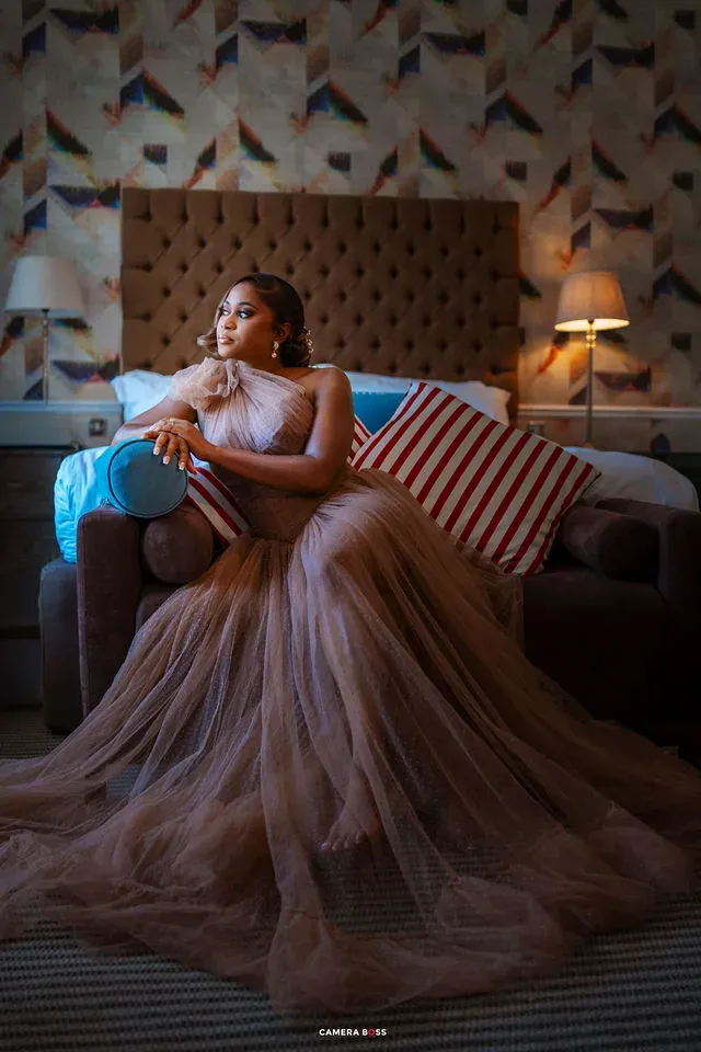 A seated bridal portrait with the dress spread beside the chair. CameraBoss portfolio: Cynthia and Oswaldo.