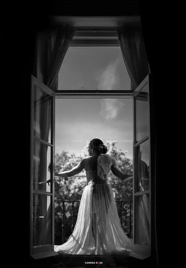 Black and white bridal silhouette beside a window. CameraBoss portfolio: Cynthia and Oswaldo.