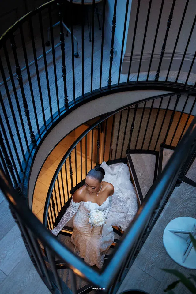 Remi framed by a curved staircase. CameraBoss portfolio: Remi and Daniel’s Bournemouth civil wedding.
