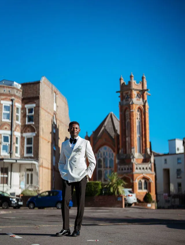 Daniel in a white dinner jacket outdoors in Bournemouth before his civil wedding