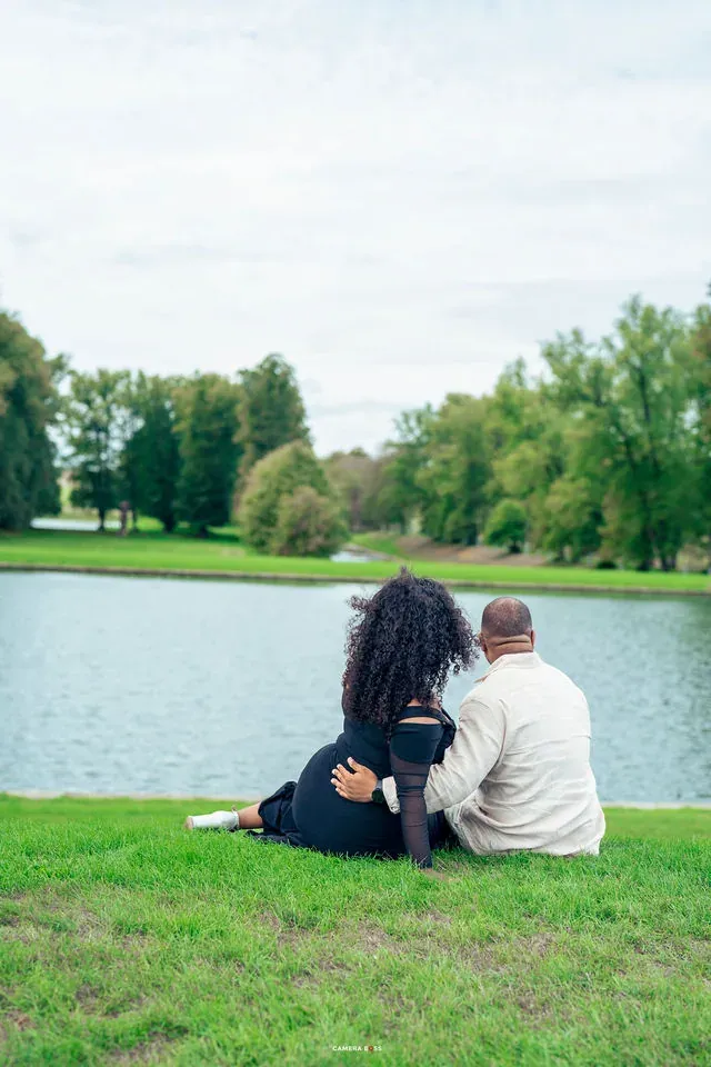 A couple seated beside the water. CameraBoss portfolio: Oney Prewedding at Boughton House.