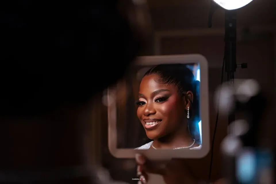 Helen's face reflected in a small mirror during her wedding preparations