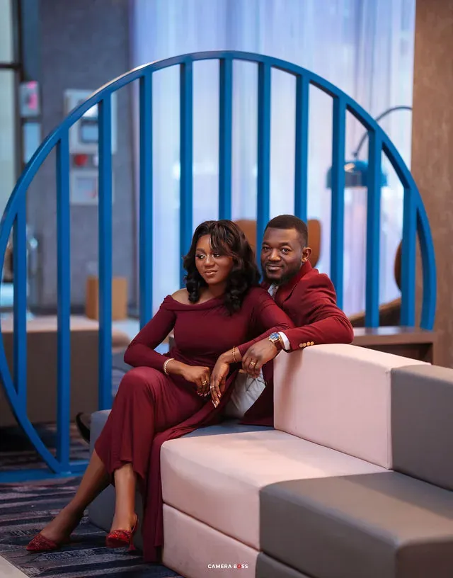 A couple seated together in front of a blue staircase. CameraBoss portfolio: Tolu Prewedding Birmingham.