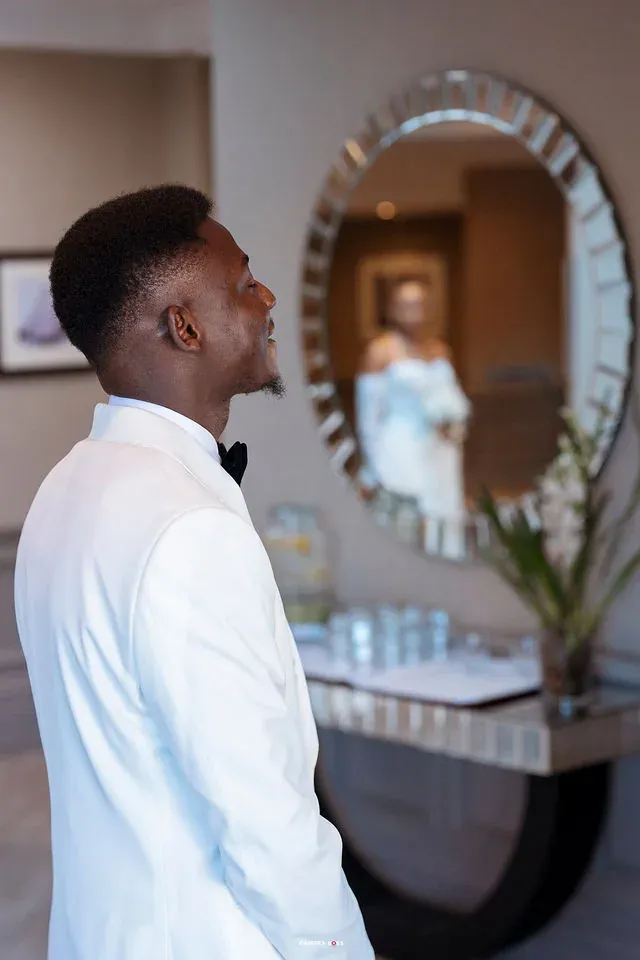 Daniel turning beside the mirror with Remi in the reflection. CameraBoss portfolio: Remi and Daniel’s Bournemouth civil wedding.