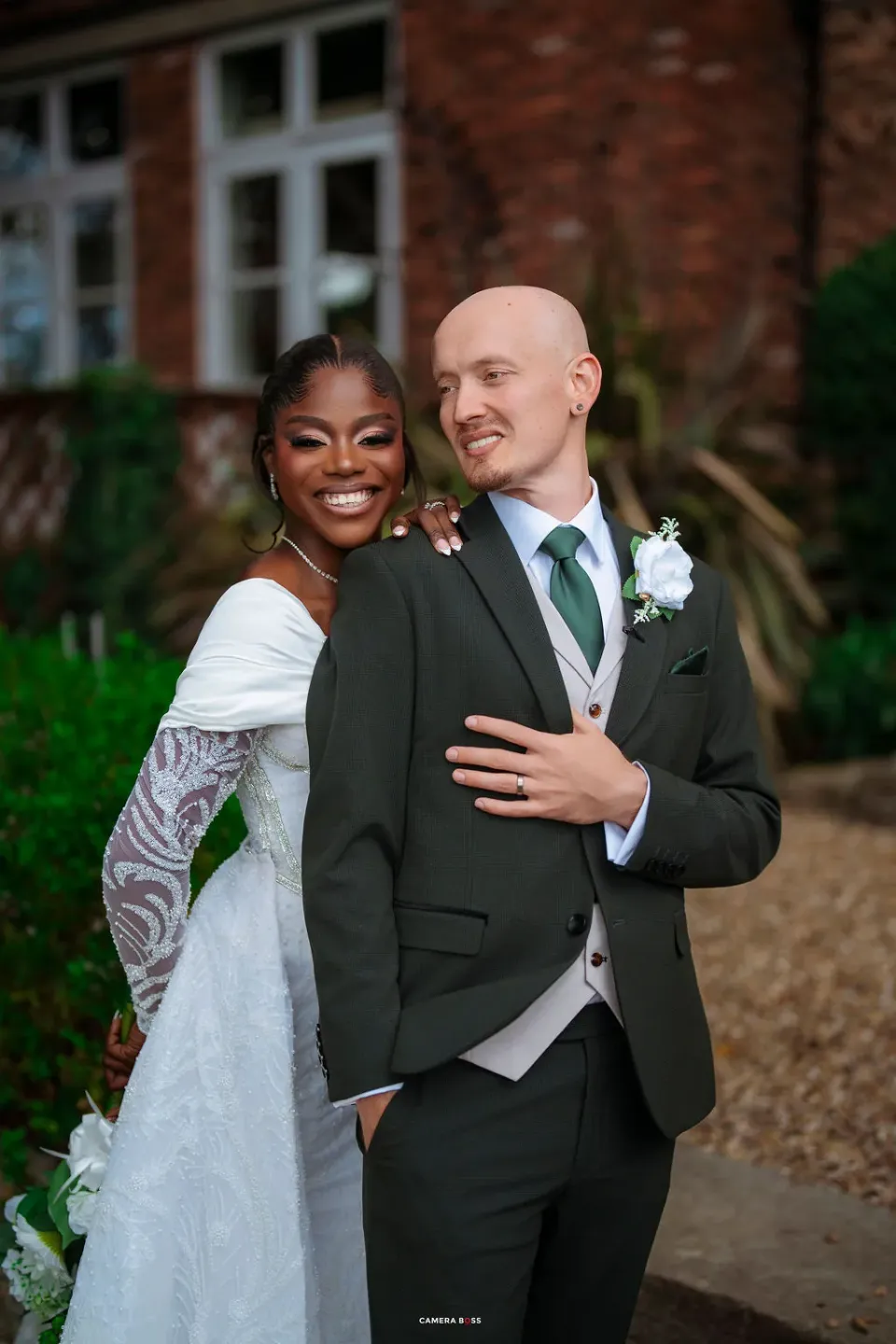 Helen smiling as Jack leans towards her during their wedding portraits