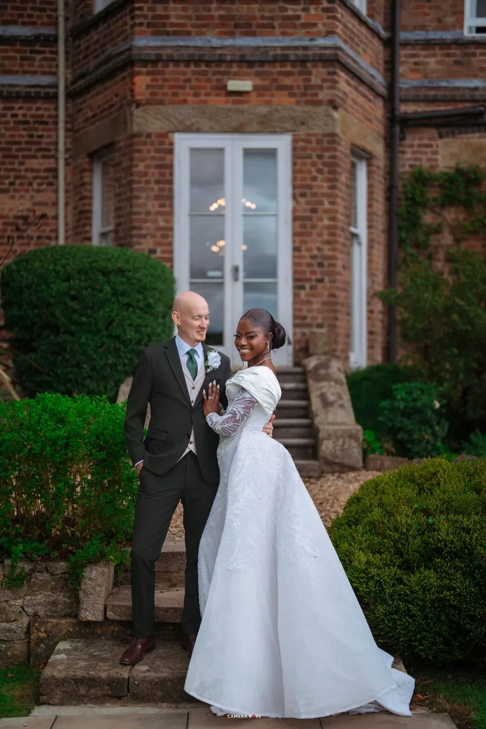 A full-length portrait of Helen and Jack together on the steps at Shottle Hall