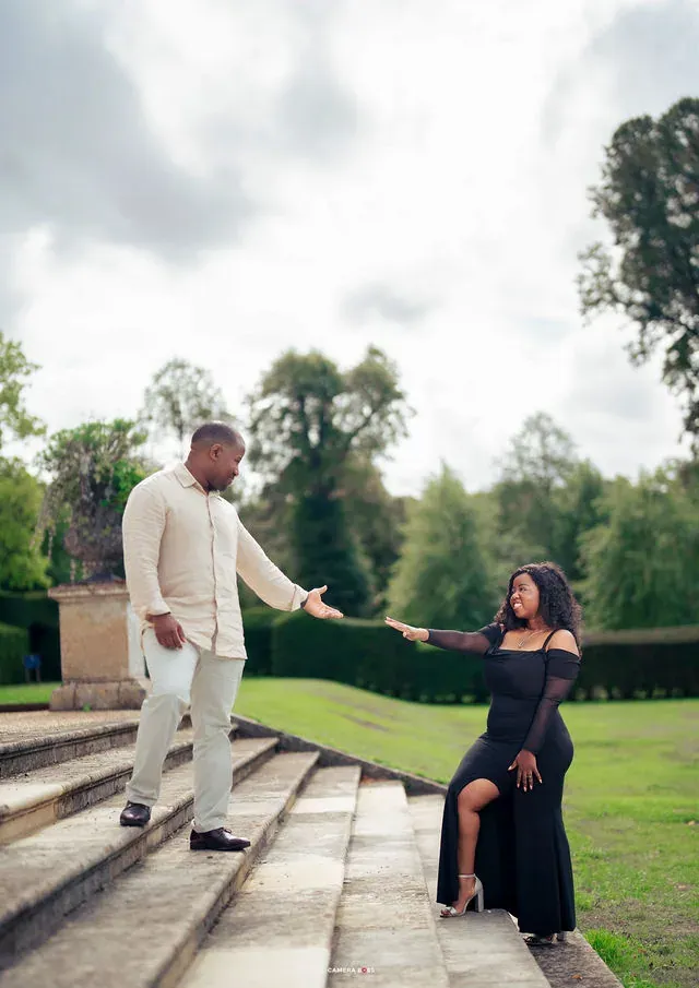 A couple holding hands on the garden steps. CameraBoss portfolio: Oney Prewedding at Boughton House.