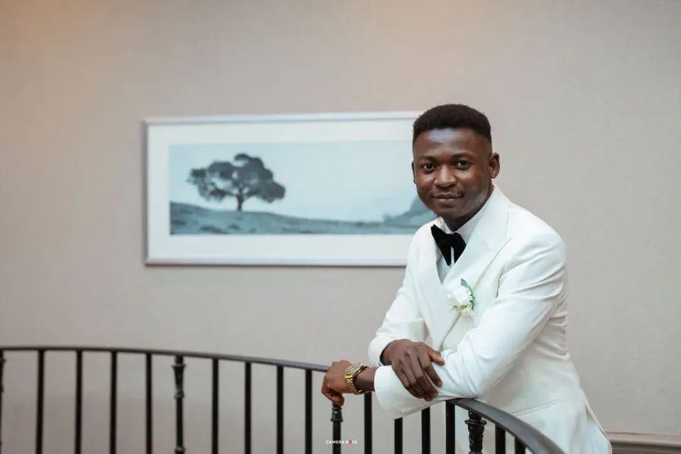 Daniel in his white dinner jacket beside the staircase railing