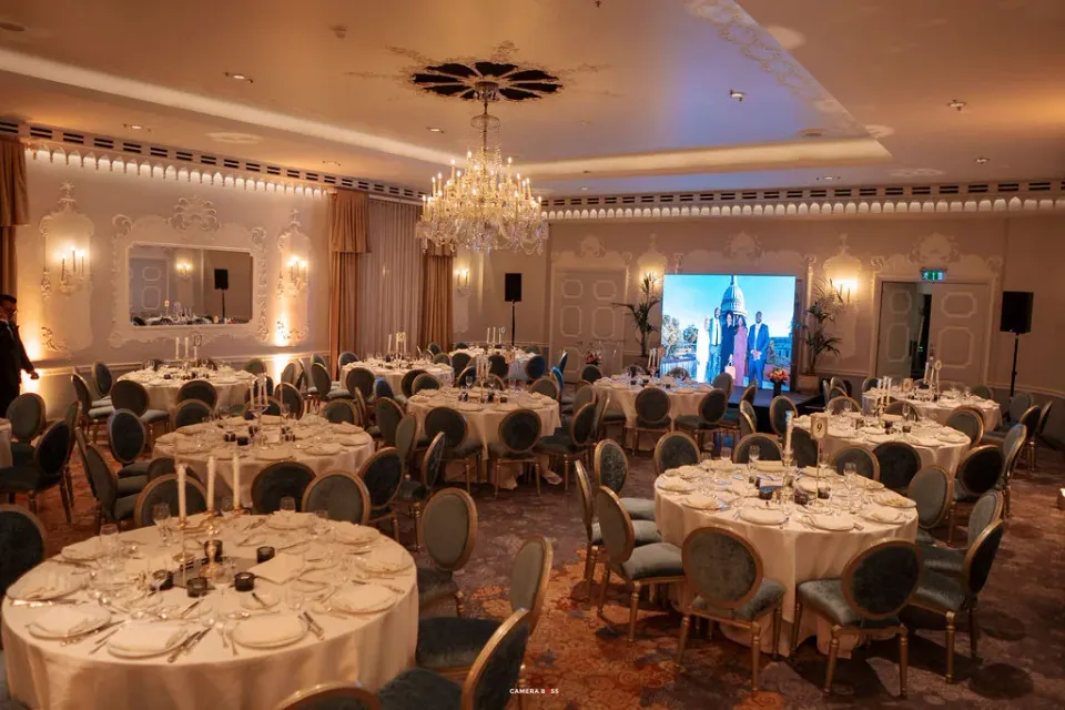 Tables set beneath chandeliers for the FLAIR Summit reception