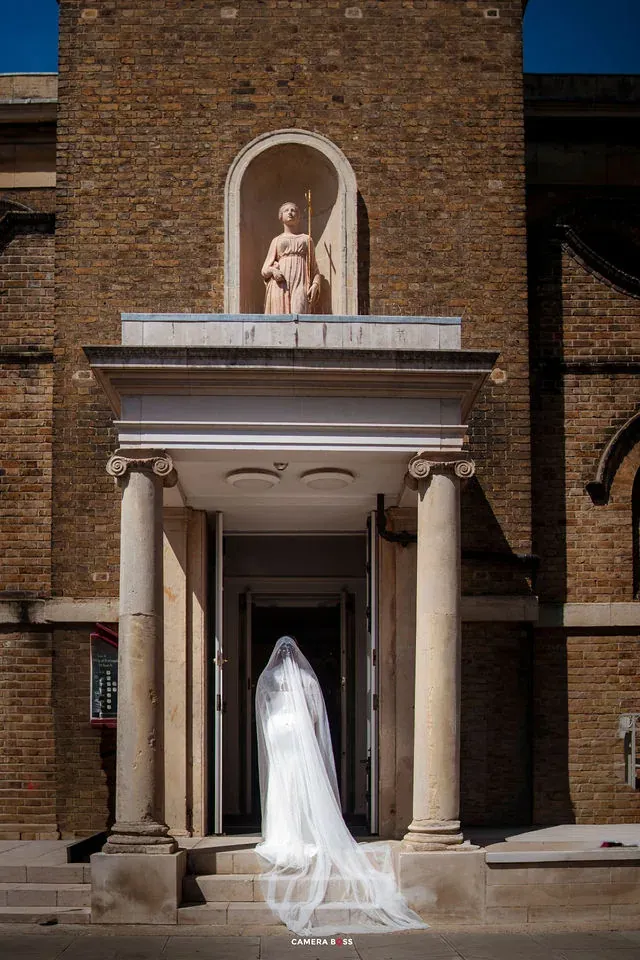 The bride and her veil seen from behind in a doorway. CameraBoss portfolio: Cynthia and Oswaldo.