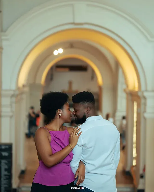 A couple embracing beneath an interior archway. CameraBoss portfolio: Tomilayo Prewedding London.