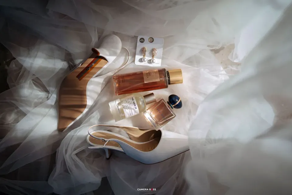 Bridal shoes and perfume arranged on pale fabric. CameraBoss portfolio: Cynthia and Oswaldo.