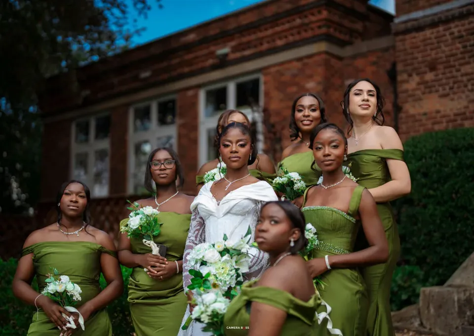 Helen with her bridesmaids in green dresses outside the brick house at Shottle Hall