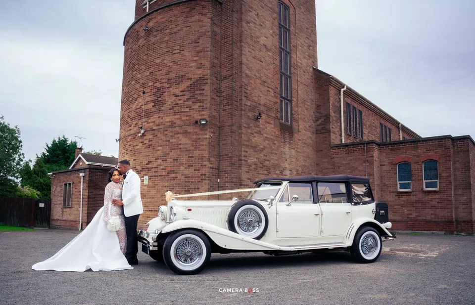 Newlyweds beside a vintage white car